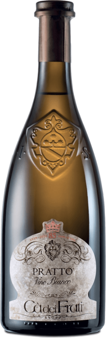 Het label heeft een klassieke, elegante vorm met sierlijke krullen en een familiewapen centraal bovenaan. Het kleurgebruik is ingetogen met voornamelijk lichte tinten en subtiele accenten. Boven het etiket is ook in het glas van de fles een reliëf van het familiewapen zichtbaar, wat extra luxe uitstraalt.