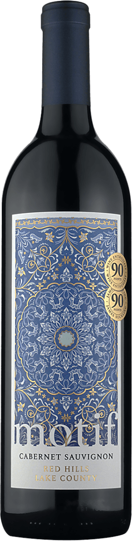 Het label heeft een gedetailleerd patroon met bloemmotieven in blauw en goud. Er zijn twee gouden medaillons die 90 punten aangeven. Onderaan staat de naam 'motif' in grote letters, gevolgd door 'Cabernet Sauvignon' en 'Red Hills Lake County'.