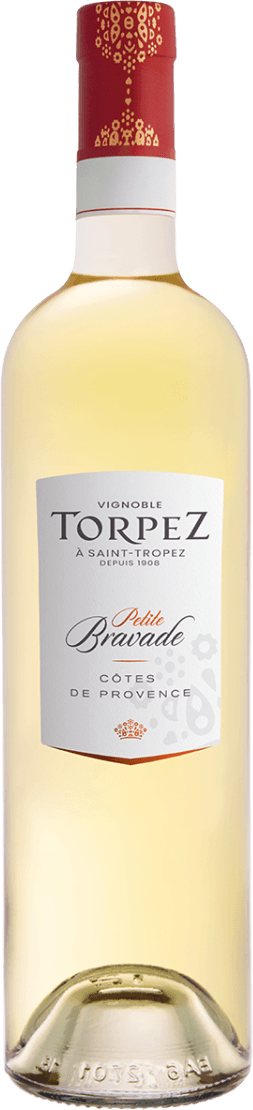 Het label is wit met een moderne, enigszins minimalistische uitstraling. De tekst 'TORPEZ' en 'Petite Bravade' zijn duidelijk zichtbaar in verschillende lettertypes, wat het label onderscheidend maakt. Onderaan staat een klein oranje-rood kroontje als detail. Op de achtergrond van het label zijn subtiele grafische elementen zichtbaar, mogelijk geïnspireerd op traditionele motieven of het lokale erfgoed.
