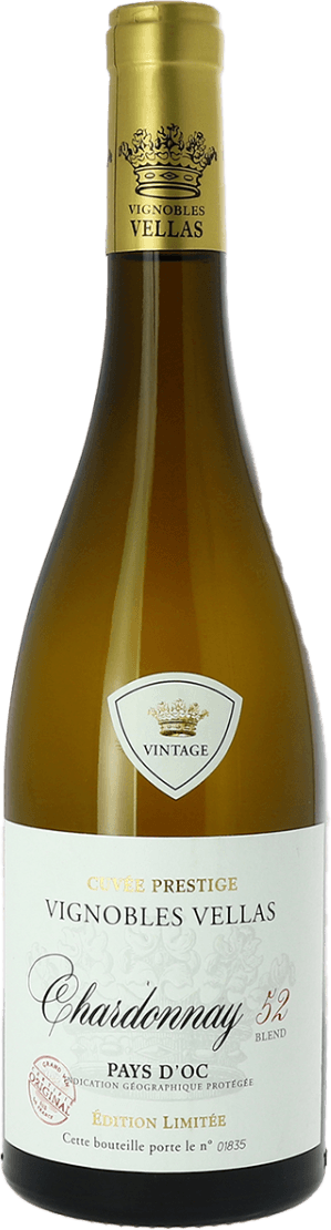 Het label is klassiek vormgegeven met een witte achtergrond en gouden accenten. Bovenaan staat een kroonembleem met het woord 'VINTAGE' in een schild, daaronder de naam van het wijnhuis 'Vignobles Vellas'. De tekst is sierlijk geschreven, vooral het woord Chardonnay. Er zijn ook enkele lichte bloemmotieven op de achtergrond zichtbaar en enkele delen van de tekst zijn in goud gedrukt. Onderaan staat een uniek flesnummer.