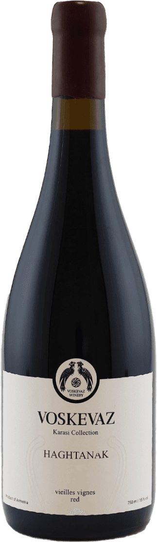 Het label is overwegend wit/crèmekleurig met een eenvoudige, klassieke uitstraling. Bovenaan staat een zwart rond embleem met daarin twee gestileerde vogels of dieren tegenover elkaar en een decoratief symbool ertussen. Daaronder staat in grote zwarte letters 'VOSKEVAZ' met kleinere tekst eronder. Het label bevat verder weinig illustraties of kleur, en heeft een traditionele uitstraling.