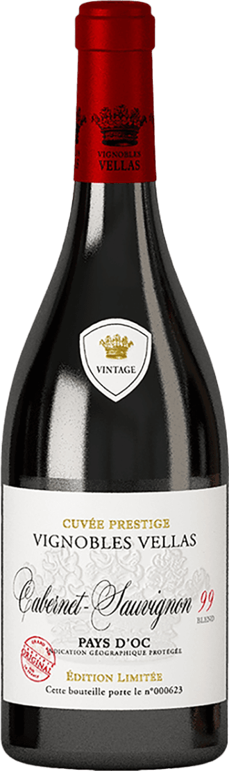 Vignobles Vellas - Blend 99 Het label heeft een witte achtergrond met sierlijke zwarte letters. Bovenaan staat 'Cuvée Prestige Vignobles Vellas'. In het midden is er een embleem met een kroon en het woord 'Vintage' erin. Onderaan staat 'Cabernet Sauvignon' in cursieve letters, gevolgd door 'Pays d'Oc'. Er zijn ook rode accenten zoals de cijfers '99' en enkele stempels.